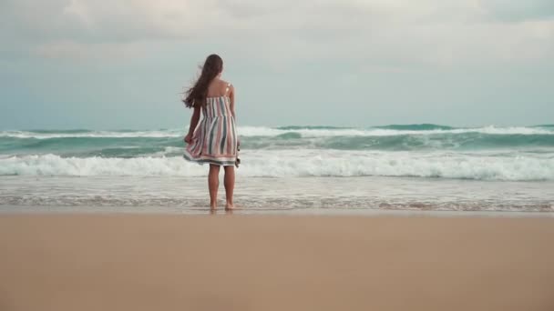 Een jonge vrouw die naar de kust wil stormen. gelukkig tiener wandelen in zee surfen. — Stockvideo