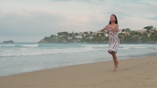 Veselá holka tančí na pobřeží. Usmívající se žena odpočívající na písečné pláži. — Stock video