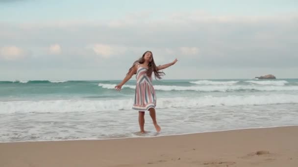 Mujer sonriente disfrutando de vacaciones en la costa. Chica feliz bailando en la playa. — Vídeo de stock