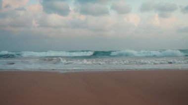 Bulutlu bir günde güzel bir fırtına manzarası. Dalgalar gün batımı plajında akıyor.