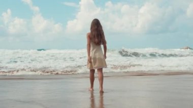Mutlu kız deniz kenarında yaz gündoğumunun tadını çıkarıyor. Genç bayan deniz kıyısında kalıyor..