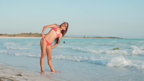 Bonita mujer pasando vacaciones en la playa. Chica haciendo ejercicios en la playa. — Vídeos de Stock