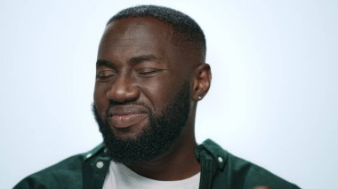 Yakın plan ciddi bir Afrikalı adam başını sallıyor hayır kameraya gri arka plan.