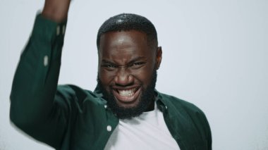 Gülümseyen Afrikalı adamın portresi gri arka planda evet işareti gösteriyor..