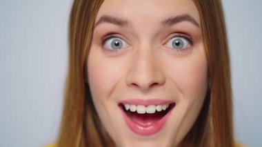 Stüdyoda gri arka planda poz veren şaşırmış güzel bir kadının portresi.. 