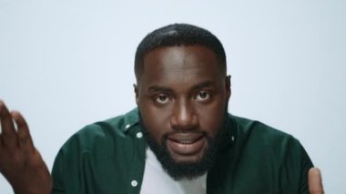 Stüdyoda kameraya soru soran kafası karışmış Afrikalı bir adamın portresi.. 