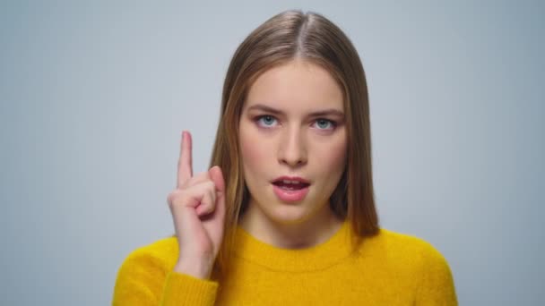 Portrait of ambisius woman pointing finger on camera on grey background. — Stok Video