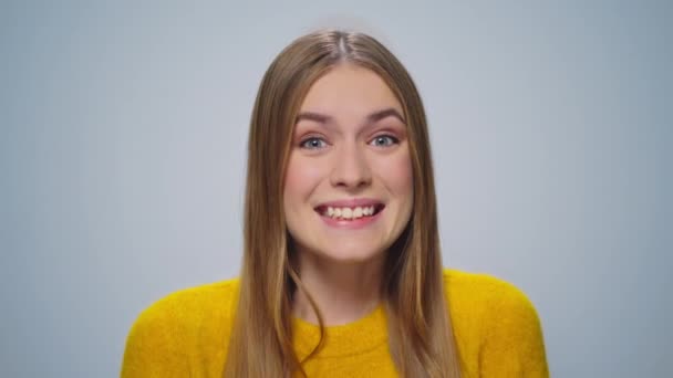 Retrato de mulher atraente feliz sorrindo para a câmera em fundo cinza. — Vídeo de Stock