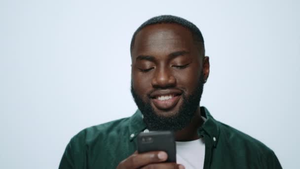 Portrait of smiling african american man using smartphone on grey background. — Stock Video