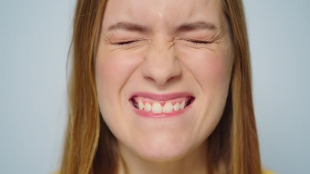 Closeup veselá žena dělat legrační obličeje na šedém pozadí ve studiu. — Stock video