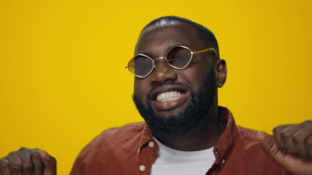 Closeup happy african american handsome dancing on yellow background. — Stok Video