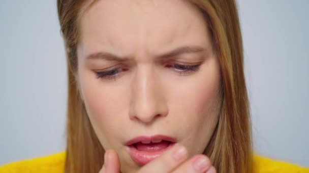 Closeup sick young woman coughing at camera on grey background. Lady feeling bad — Stock Video