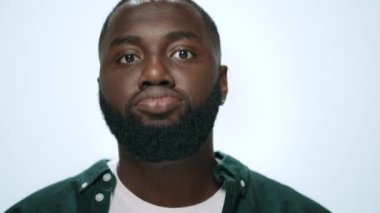 Gri arka planda komik suratlar yapan heyecanlı Afrikalı Amerikalı adamın yakın çekimi..