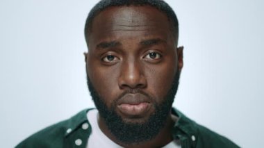 Stüdyoda gri arka planda gülümseyen Afrikalı Amerikalı bir adamın portresi..