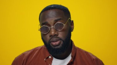 Yakın plan Afro-Amerikalı adam sarı arka planda evet diyor..