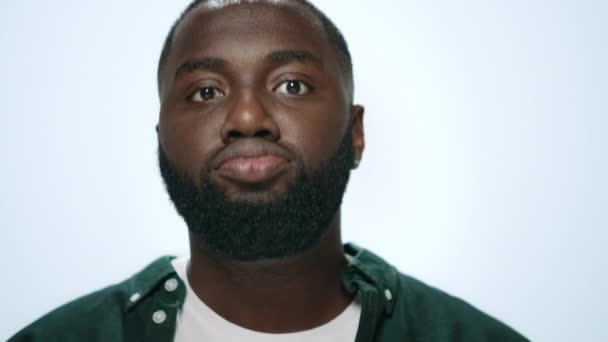 Detailní záběr vzrušený africký Američan dělá legrační obličeje v šedém pozadí. — Stock video
