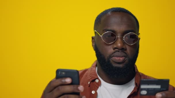 Крупним планом бородатий афро-хлопець використовує кредитну картку для онлайн оплати в студії . — стокове відео