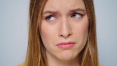 Stüdyodaki gri arka planda kameraya bakan endişeli kadın.. 