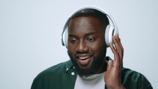 Πορτρέτο του θετικού Αφρικανού άνδρα που ακούει μουσική σε ακουστικά στο στούντιο. — Αρχείο Βίντεο