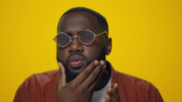 Retrato de homem afro-americano sério verificando barba no fundo amarelo. — Vídeo de Stock