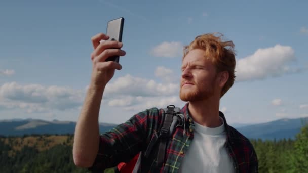 Um homem a apanhar sinal de telemóvel nas montanhas. cara segurando smartphone na mão — Vídeo de Stock