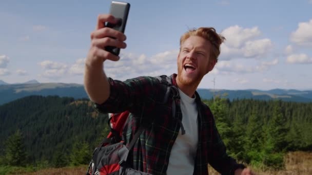 ハイカーは山の中の携帯電話で写真を撮る。男取りますセルフィーオン携帯電話 — ストック動画