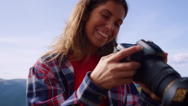 Caminante con cámara profesional en las montañas. Chica mirando fotos en la cámara — Vídeo de stock