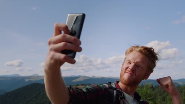 녹색 산 속에서 셀카 사진을 찍은 긍정적 인 남자 — 비디오