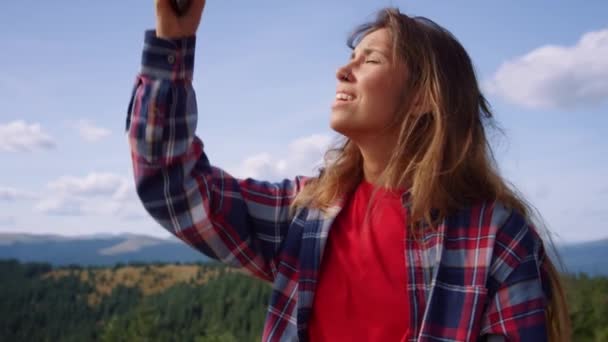 Vrouw vangt mobiel signaal op in de bergen. Meisje springen in de lucht met smartphone — Stockvideo