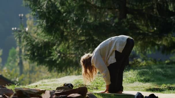 Yoga-Frau entspannt sich in den Bergen. Meditatives Mädchen bleibt auf sonnigem Hügel. — Stockvideo