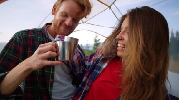 Couple assis dans une tente ensemble. Femme heureuse et homme cliquetis tasses avec du thé — Video