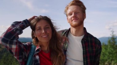 Dağın tepesinde gülümseyen yürüyüşçüler. Dağlarda yürüyüş yapan bir çift