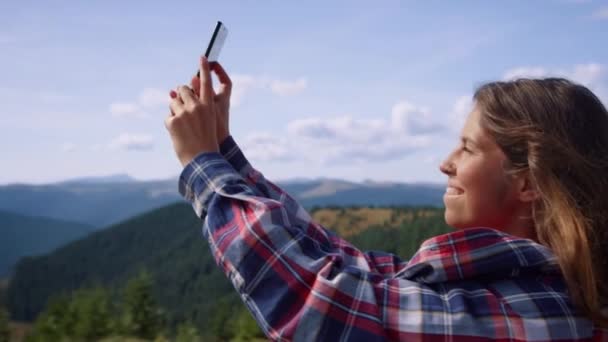 スマートフォンで風景写真を撮る少女。ブロガーは、携帯電話でビデオを作る — ストック動画
