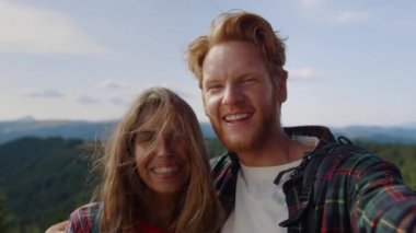 Dağlarda görüntülü konuşma yapan turistler. Erkek arkadaşın kız arkadaşına sarılıyor.