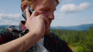Dağlarda cep telefonuyla konuşan gülen adam. Hhiker kötü haberler alıyor.