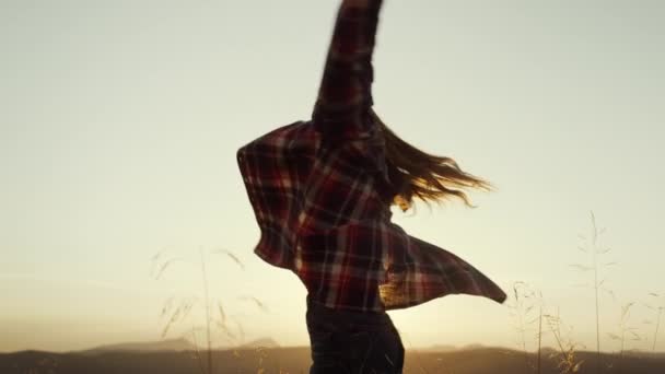 Girl having fun in mountains at sunset. Smiling female tourist raising hands — Stock Video