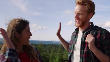 Adam ve kız dağlarda beşlik çakıyor. Mutlu çift başarıyı kutluyor