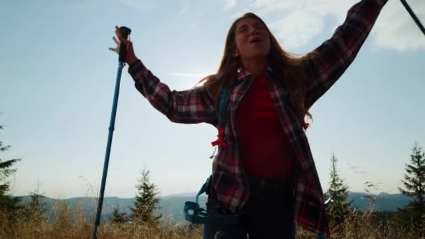 Γυναίκα τουρίστρια στέκεται στην κορυφή του βουνού. Ευτυχισμένο κορίτσι που σηκώνει τα χέρια ψηλά. — Αρχείο Βίντεο