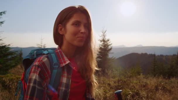 Lachend meisje trekking in de bergen in de zomer. Vrouwelijke reiziger wandelen in het veld — Stockvideo