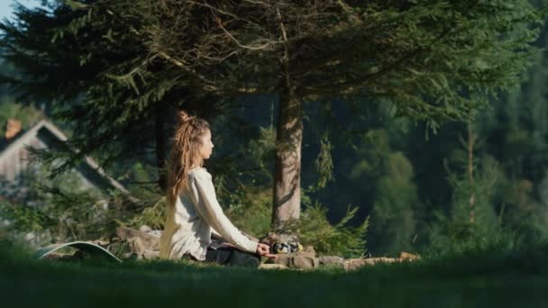 Yoga-Frau genießt Sonnenaufgang in den Bergen. Hübsches Mädchen macht Yoga im Wald. — Stockvideo