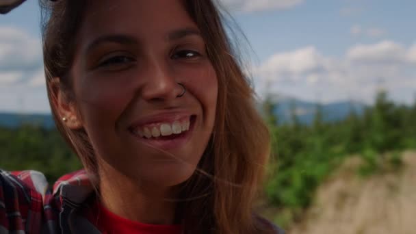 Donna sorridente che tocca i capelli con mano. Escursioni delle escursioniste nelle montagne estive — Video Stock