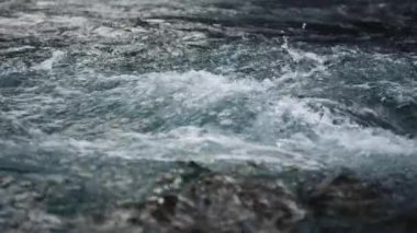 Dağ nehrinde akan nehir suyu. Ağır çekimde hızlı su akışı