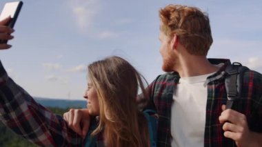 Dağlarda akıllı telefondan video çeken bir çift. Yürüyüşçüler görüntülü konuşma yapıyor 
