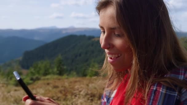 Chica usando smartphone en las montañas. Mujer escribiendo mensaje en el teléfono móvil — Vídeos de Stock