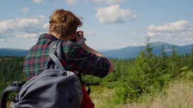 Erkek fotoğrafçı dışarıda fotoğraf makinesi kullanıyor. Yürüyüş sırasında fotoğraf çeken adam. 