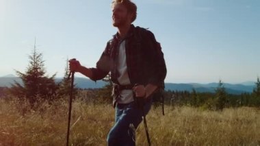 Yaz tatilinde dağlarda yürüyüş yapan erkek turist. Tarlada duran mutlu adam