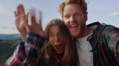 İnternette sohbet eden neşeli bir adam ve kadın. Yürüyüşçüler kameraya el sallıyor