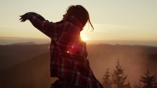 Девушка делает смешные движения во время танцев в горах. Счастливая женщина танцует под открытым небом — стоковое видео