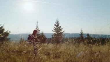 Çimen tarlasında yürüyüş yapan bir kadın. Dişi turist dağlarda yürüyor.