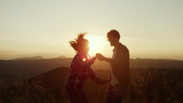 Mujer y hombre bailando en la cima de la montaña. Pareja haciendo movimientos divertidos durante la danza — Vídeos de Stock